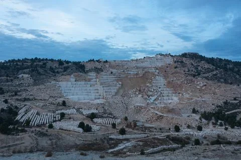 Open-air mining activity in a white marble mine. Stock Photos