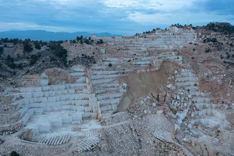 Open-air mining activity in a white marble mine. Stock Photos