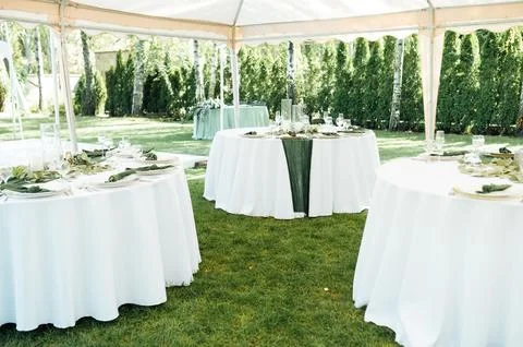 Open -air wedding banquet. The table is decorated with white plates and premium Foto stock
