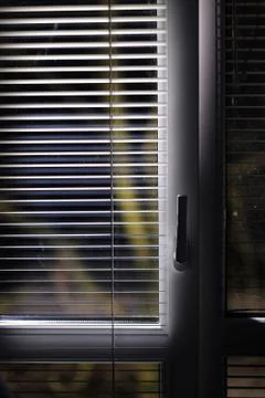 Open for airing plastic window with blinds in the evening Stock Photos