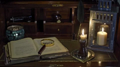 An open antique book in which a magnifying glass and a writing pen rest. are Stock Footage 219065771