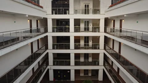 Open atrium modern office lobby multilevel balconies with glass railings Video stock 335950279