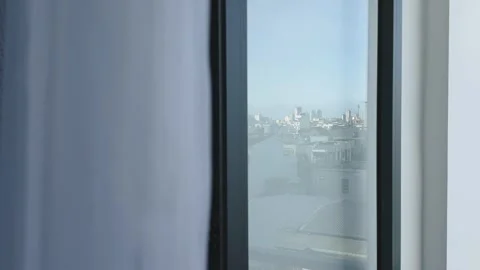 Open balcony door with moving in the draught curtain and panoramic city skyline Vídeos de archivo 342303367