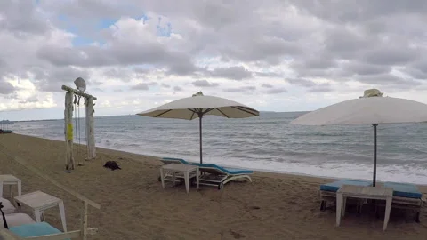 Open beach umbrellas on the Canggu beach on a rainy day Stock Footage 295416837