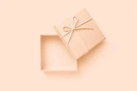 Open beige square gift box with a bow, top view Stock Photos
