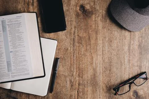 Open Bible and a open notebook on a wooden desk. Top view flat lay. Stock Photos
