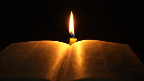 An open Bible in the dark in the light of a burning candle Stock Footage 274021006