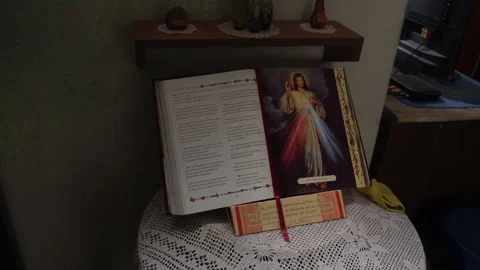 An open bible with the image of Jesus on the table in a catholic house 库存影片 140395158