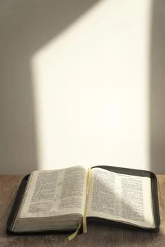 Open bible on the table. light background, sunlight. enlightenment. faith, .. Stock Photos