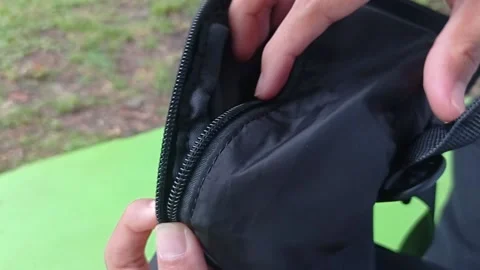 Open a black bag on a grass background Stock Footage 146246763