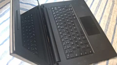 Open black laptop computer resting on top of striped fabric surface Stock Photos