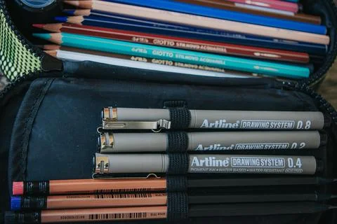 Open black pencil case filled with colored pencils. Stock Photos