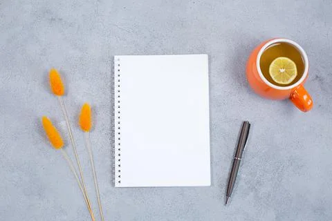 An open blank diary notebook, calendar with dried grass and cup of tea on grey Stock Photos