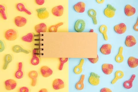 Open blank notebook on background of gummy candies. Multicolored candies on y Foto stock