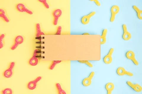 Open blank notebook on background of gummy candies. Gummy candies on yellow a Stock Photos