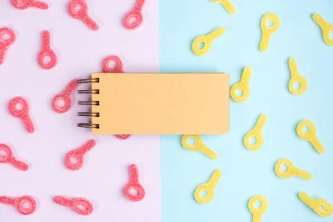 Open blank notebook on background of jelly candies. Red and yellow gummy cand Stock Photos