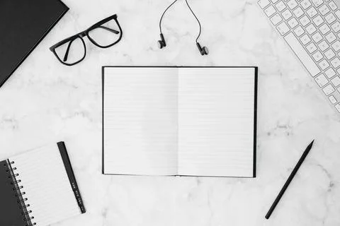Open blank notebook with eyeglasses diary pencil earphone keyboard white desk Stock-Fotos