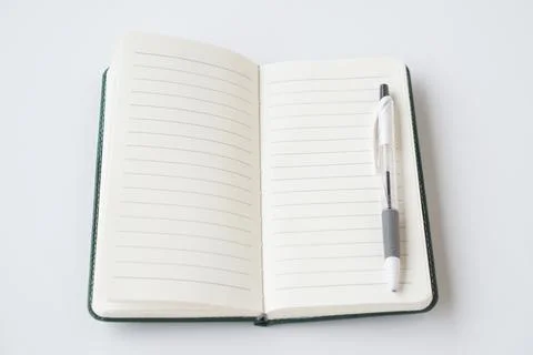 Open blank notebook with lined pages and pen placed on top, isolated on white ba Stock Photos