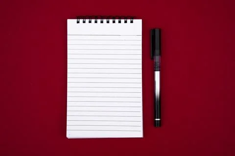 Open Blank Notebook with Pen on Bold Red Background for Creative Concepts Stock Photos