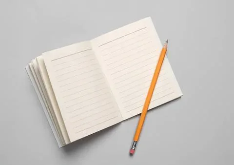 Open blank notebook with pencil on a gray background Stock Photos