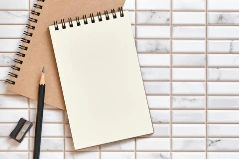 Open Blank Notebook, Pencil Sharpener and pencil on White Tile Background Foto stock