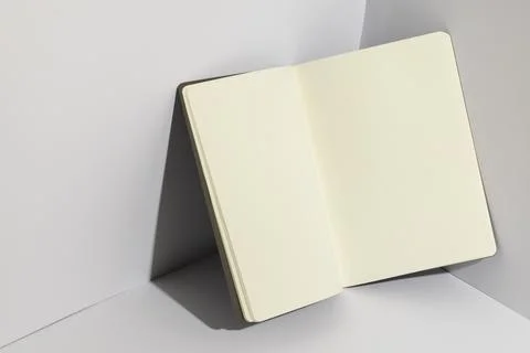 An open blank notebook rests on a white surface, with copy space Stock Photos