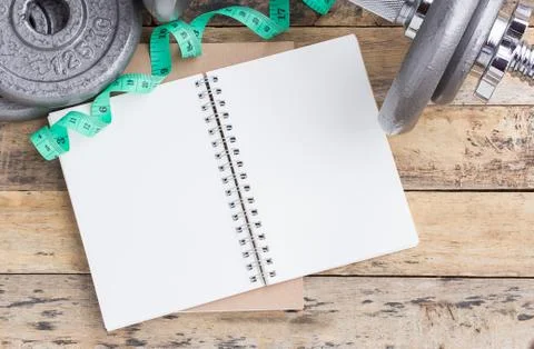 Open blank notepad and dumbbell Stock Photos