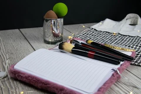 Open blank page notebook template, make up brushes and a eye shadows palette on Stock Photos