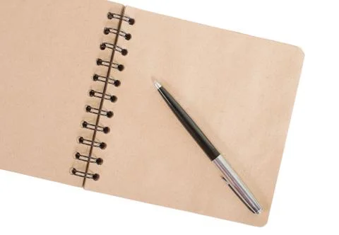 Open blank square notebook of brown kraft paper with a spiral and ballpoint p Stock Photos