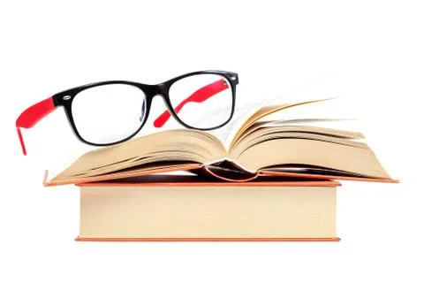 Open book and glasses on a stack of books Stock Photos