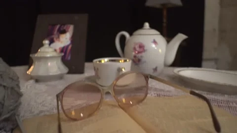 Open book and glasses for vision. scary room.  porcelain cups and teapot  Stock Footage 142652893