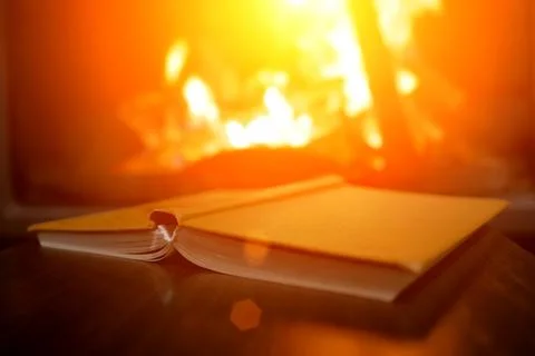 Open book on the background of a burning fireplace Stock Illustration