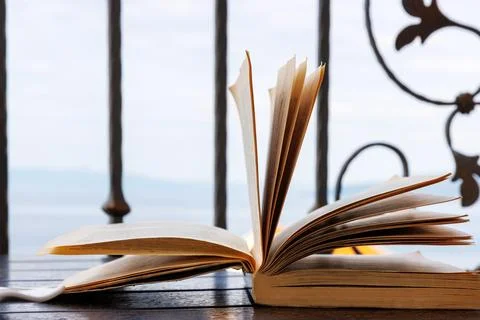 Open book on a balcony table overlooking the Adriatic Sea in Makarska, Croati Stock Photos