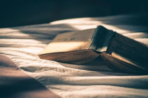 Open book on bed Stock Photos