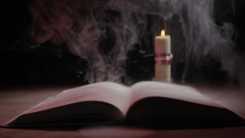 Open Book With Burning Candle And Swirling Smoke In Dark Mystic Atmosphere Stock Footage 326627414