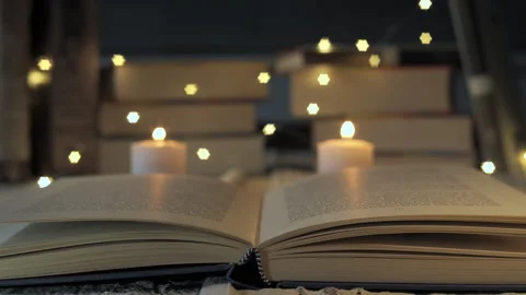 Open book changing focus with burning candles and fairy lights Stock Footage 291705270