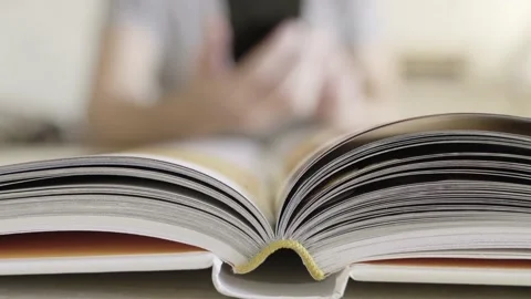 Open book close-up and in blurred background man with smartphones taking picture Stock Footage 163989387