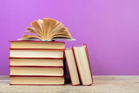 Open book. Composition with hardback books, fanned pages on wooden deck table Stock Photos