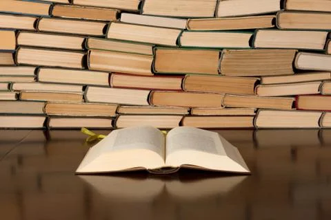 Open book on the desk with background of book piles Stock Photos