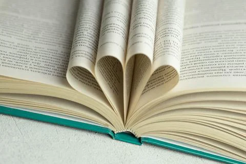 An open book with folded pages in the shape of a heart Stock Photos