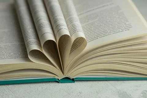 An open book with folded pages in the shape of a heart Stock Photos