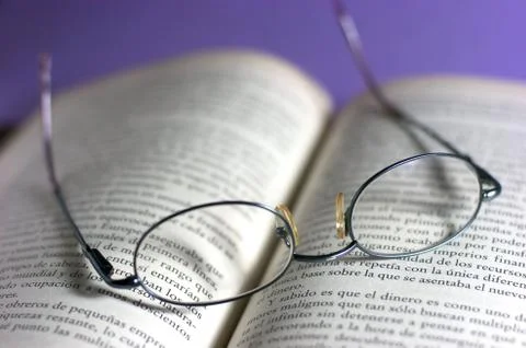 Open book with glasses Stock Photos