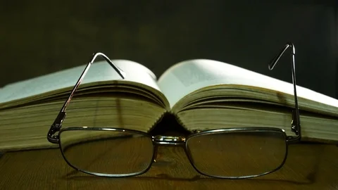 Open Book with Glasses on the Used Table. Zoom in. Stock Footage 94088741
