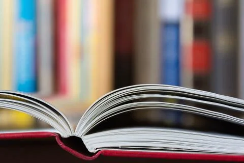 Open book with a library in background Stock Photos