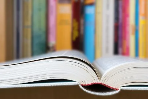 Open book with a library in background Stock Photos