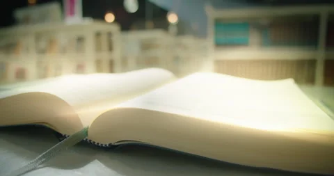 Open book in library glows with magical rays. Video stock 237965348