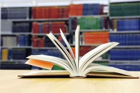Open book on library table Stock Photos