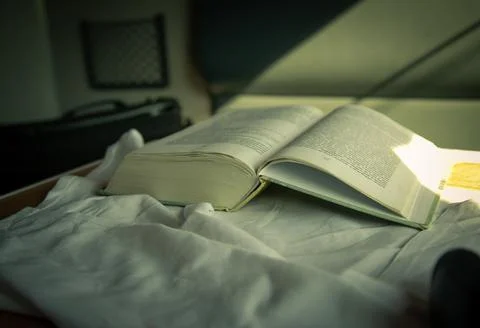 The open book lies on the table in the train compartment. Stock Photos