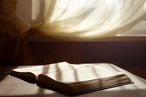 An open book lies on a table under the rays of the sun, the rays of the sun Stock Photos