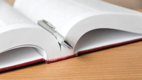 Open book with pen Stock Photos